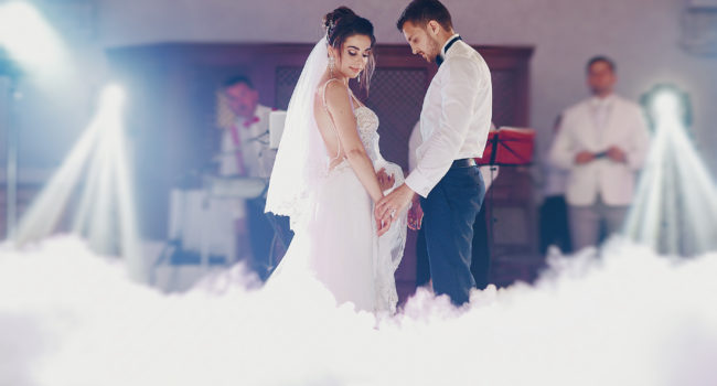 the bride and her husband dance together their first wedding dance in the restaurant